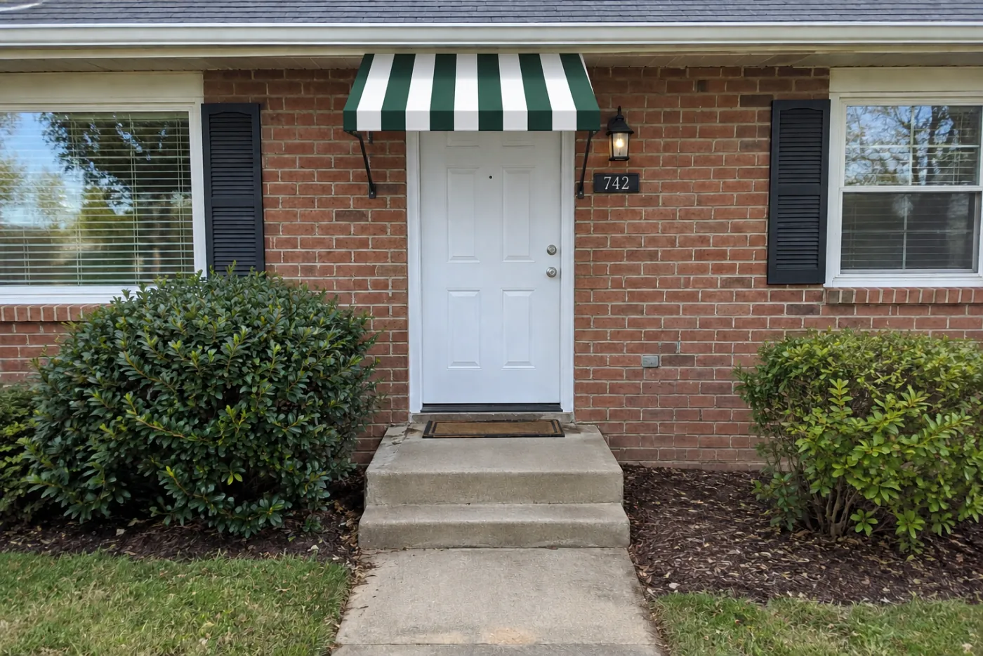 A green and white striped awning over a front door