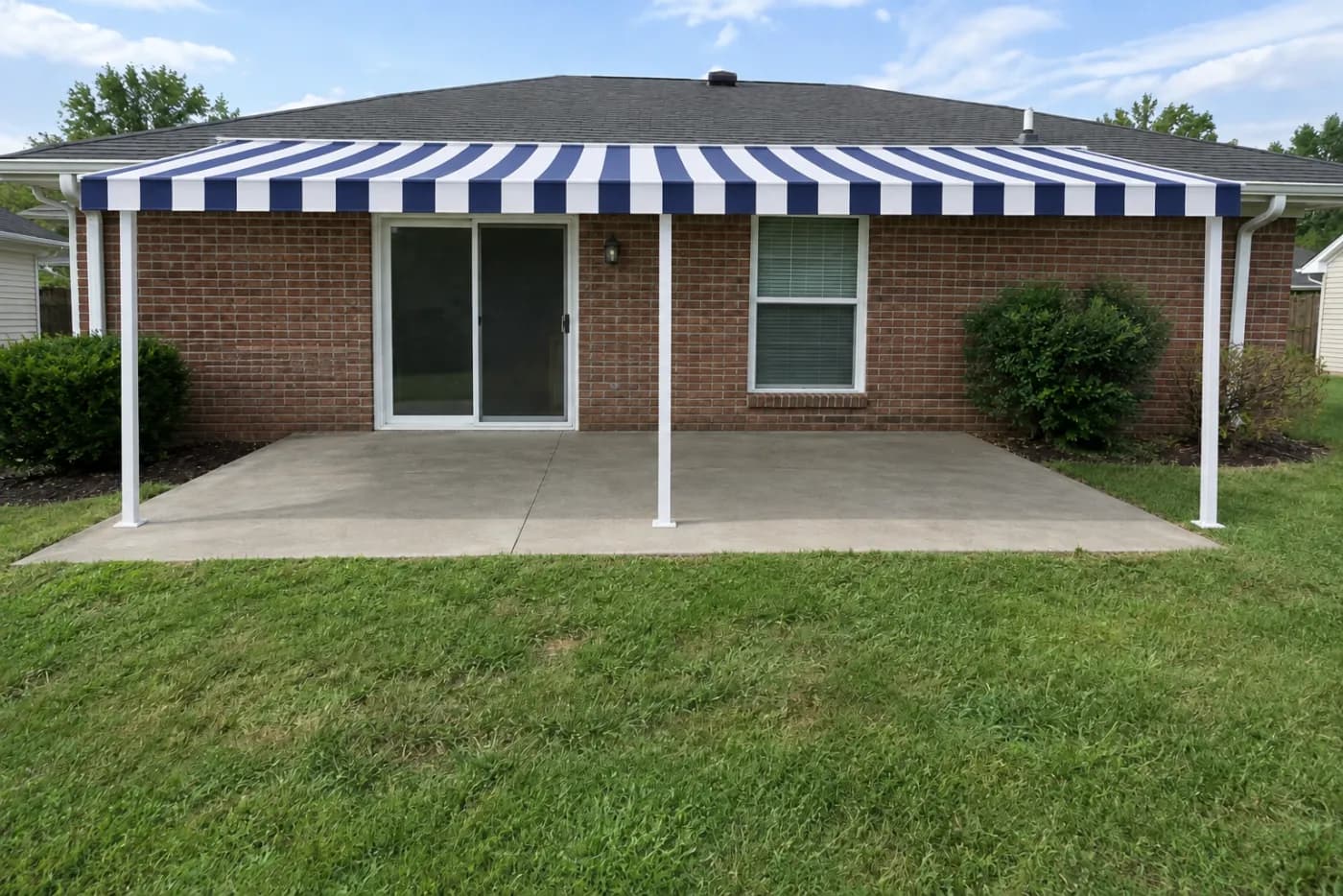 A navy striped patio awning carried on white posts