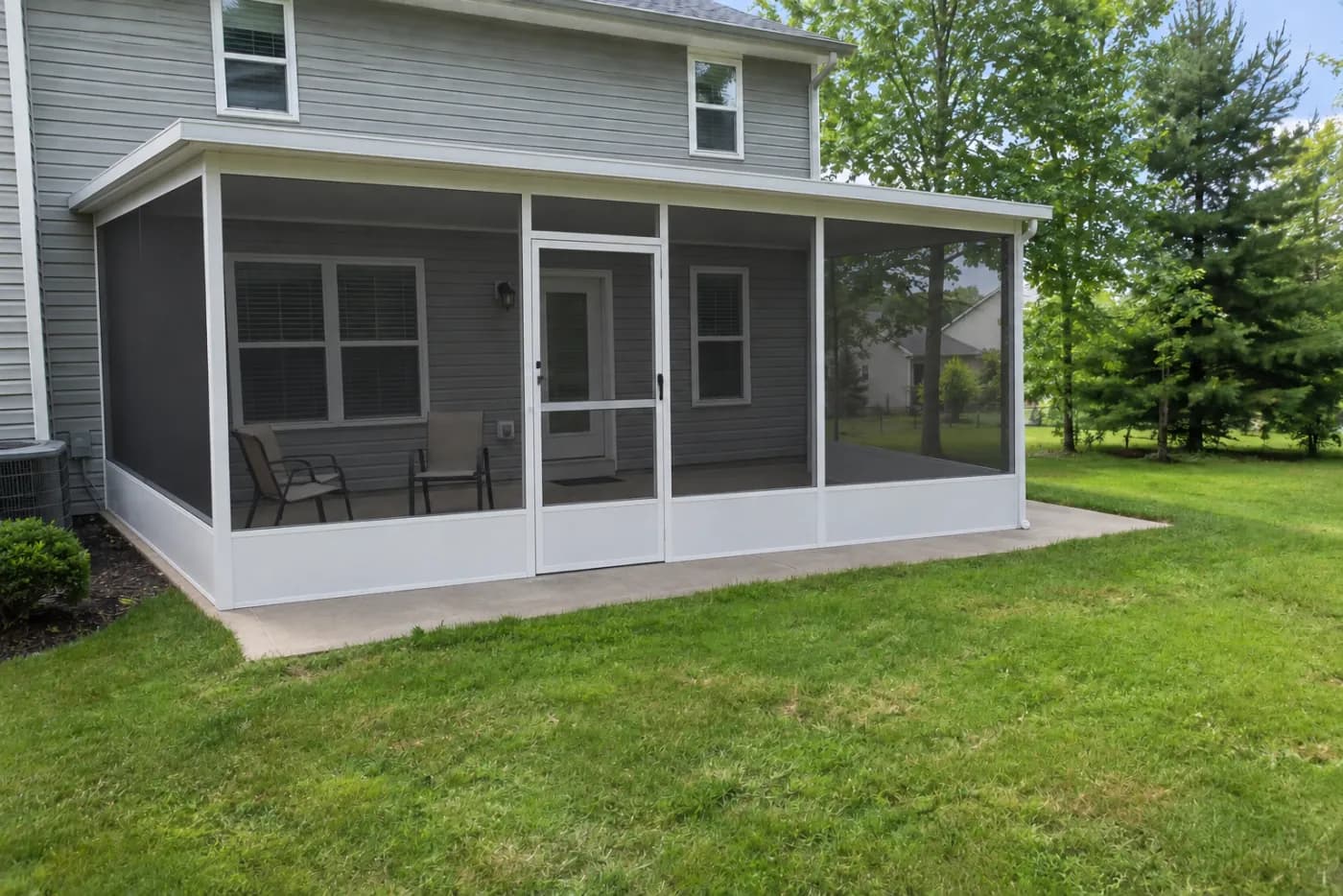 A screened patio enclosure on the back of a house